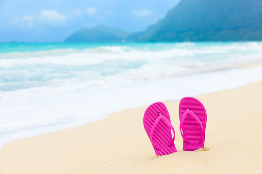 Beach holiday concept. Pair of colorful sandals on a tropical beach. (location Hawaii) 