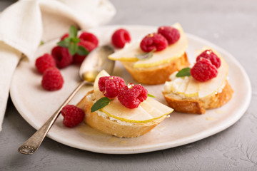 Open faced sandwiches with cheese, pears and raspberry