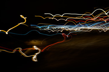 light trails from a vehicle on a snowy winter’s night form an abstract gun