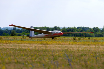 Fototapeta na wymiar Glider landing after flight in blue sky