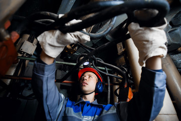 man in the underground mine repairs the hydraulic pipes. Concept work in difficult conditions.