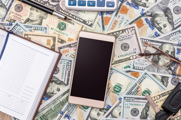 dollar as background, phone, pen and notebook