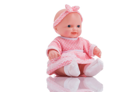 Cute little plastic baby doll with blue eyes sitting  isolated on white background