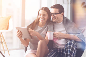 Happy couple watching video in tablet