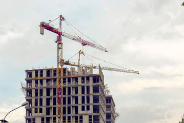 Monolithic concrete frame of the building and the red crane