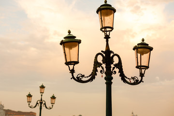 Fototapeta na wymiar glowing street lamp on mediterranean sunset