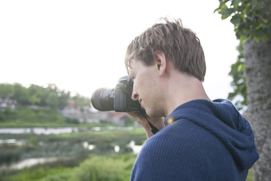 Man with camera taking a photo during sunset