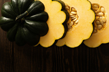 Sliced raw acorn squash on dark background