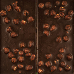 Chocolate background. Milk chocolate with hazelnuts close-up.