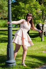 Beautiful young woman wearing elegant white dress standing in the park