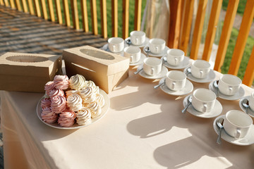 Still life with homemade marshmallows, meringues and tea set many cups