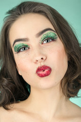 fun girl with bright cosmetics on green background