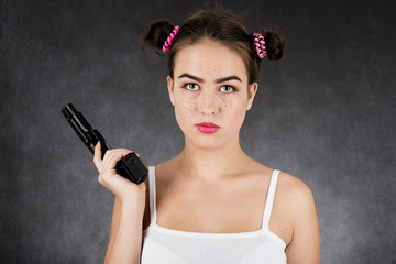 serious girl with gun on black background