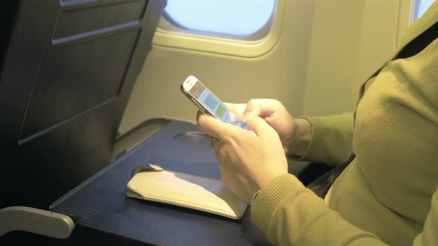 High quality video of woman using phone in the airplane in 4K