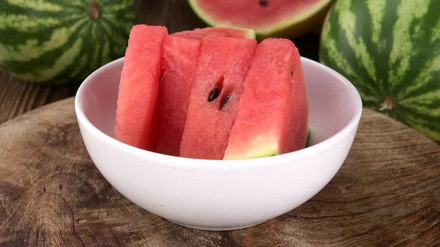 Water Melon on a rotating wooden plate (seamless loopable; 4K)