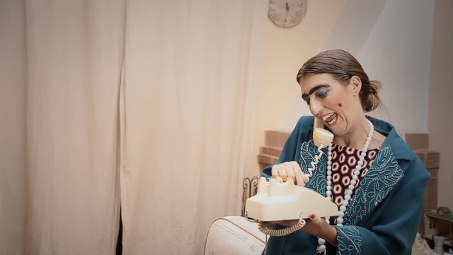 A funny ugly woman talking on a vintage rotary telephone. Medium shot.
