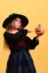 Child in witch costume and jack o lantern