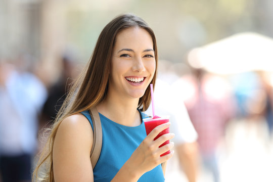 Woman holding a slush and looking at you