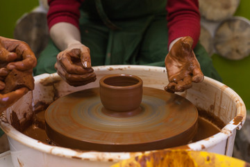 The master teaches the student pottery. Work in the pottery workshop. The Potter's wheel in operation.