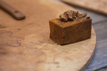 Clay for the manufacture of ceramic products rests on a foam sponge in the pottery workshop. Sponge a sponge lying on a wooden table.