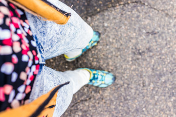 Closeup view of woman's body and clothing looking down with jeans and shoes