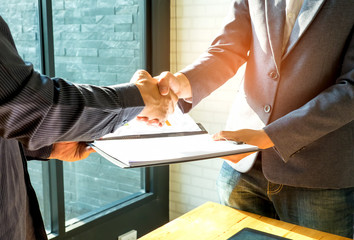 Businessmen are shaking hands and exchanging business documents.People shake hands when reaching agreement.