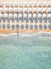 View from above, stunning aerial view of an amazing white beach with white beach umbrellas and...