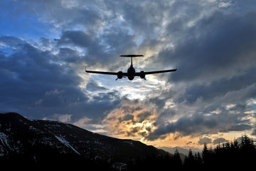 Fototapeta na wymiar passenger plane flies in juicy clouds to meet the sun.