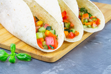 Traditional Mexican tacos with meat and vegetables on wooden background