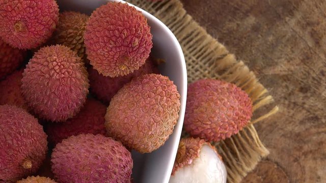 Lychees (rotating on a wooden plate; seamless loopable; 4K)