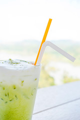 Glass of green tea ice on table