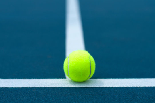 Tennis ball on tennis court with white line