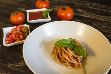  Spaghetti with tomato and basil on wooden background