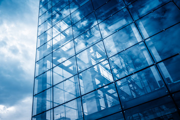 Fototapeta na wymiar modern glass building with reflection,blue toned.
