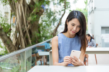 Woman using smart phone at outdoor coffee