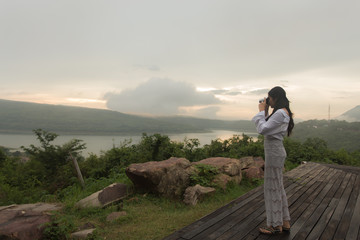 Obraz premium Female photographer taking pictures of the sunset.