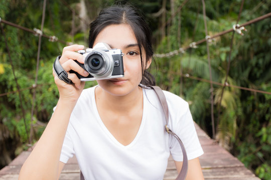 Asian woman taking photos outdoors in a forest