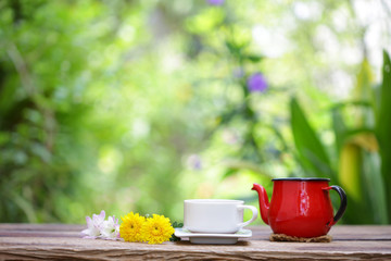 White cup with red tea pot and flower