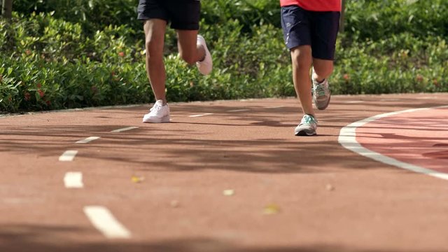 close up of running feet on red track in the morning in slow motion