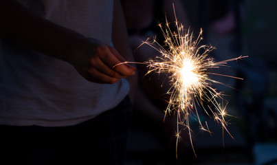 someone holding a sparkler on the fourth of july during the summer