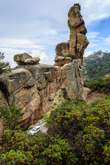 A car winds up the curving mountain highway past a stone arch in the Santa Catalina Mountains near Tucson, AZ.