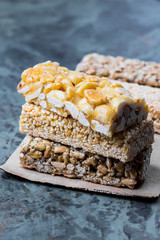 Nuts bars in caramel, honey on gray table background. Snack food. Unhealthy eating. Copy space