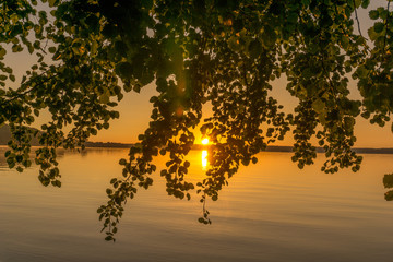 Sunrise over a small lake with trees