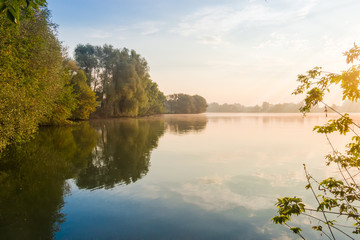 Pond with trees on a shores at sunrise