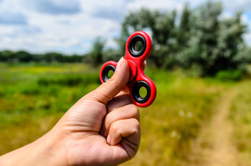 Red fidget spinner in female hand