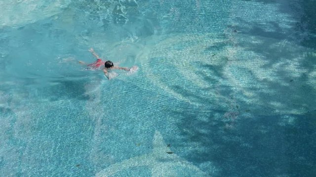 high angle view of Asian boy swimming in summer in slow motion