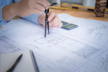 Architect or planner working on drawings for construction plans at a table