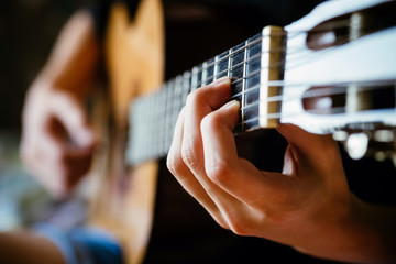 Fototapeta premium young musician playing acoustic guitar, live music background