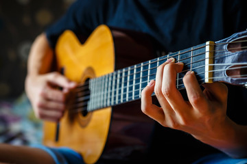 Fototapeta premium young musician playing acoustic guitar, live music background