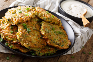 Freshly cooked Zucchini pancakes with sour cream close-up. horizontal